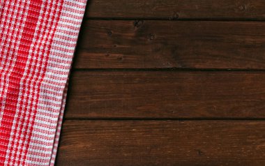 Kahverengi ahşap masa üzerinde kırmızı damalı piknik bezi.