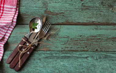 Rustik çatal bıçak, kaşık, çatal seti. Turkuaz arka plan. Üstte görüntü.