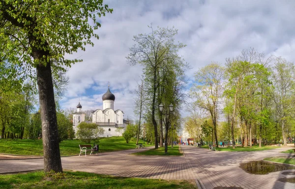 Antiguo templo de piedra cristiana ortodoxa. Pskov, Pskov. La Iglesia de St. Basilio el Grande en la colina sobre un fondo de hierba verde y hermoso cielo azul con nubes blancas esponjosas . —  Fotos de Stock