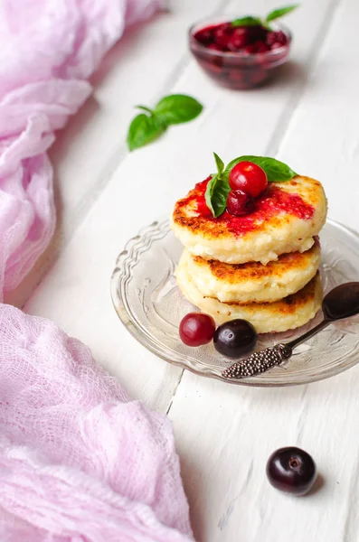 Cottage cheese pancakes on a dark background. Syrniki with fresh mint. Pancakes with cottage cheese on a lilac plate . Homemade food.