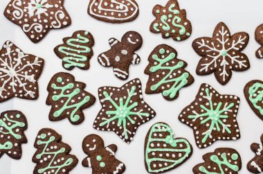 Beyaz arka planda zencefilli kurabiye. Kar tanesi, yıldız, insan, kalp şekilleri.