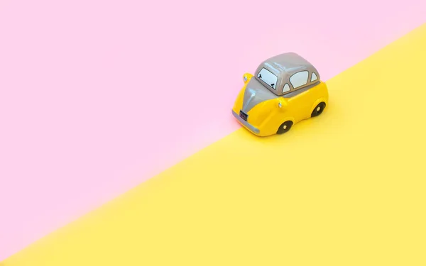 Gelbes Spielzeugauto Vereinzelt Auf Rosa Und Gelben Hintergrund Fest Oder — Stockfoto