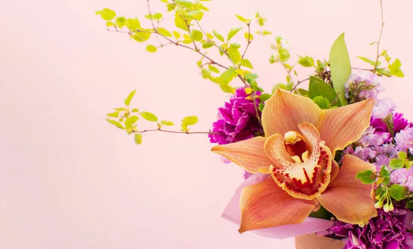 Bir demet güzel çiçek, açık pembe arka planda izole edilmiş orkide. Yakın plan. Çiçekçi dükkanı ya da ziyafet konsepti.