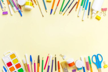 Sarı kağıtta farklı renkte okul malzemeleri var. Okul geçmişine dönelim. Düz konum, üst görünüm, kopyalama alanı.