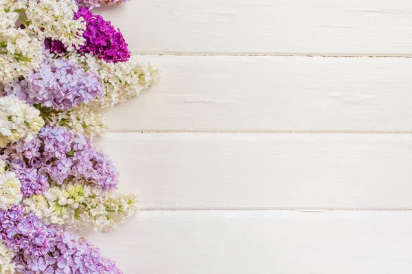 Beyaz ahşap arka planda eflatun çiçekleri dalları var. Bahar ya da Anneler Günü konsepti