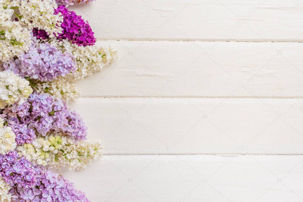 Lilac flowers branch on white wooden background with copyspace. Spring or mother day concept