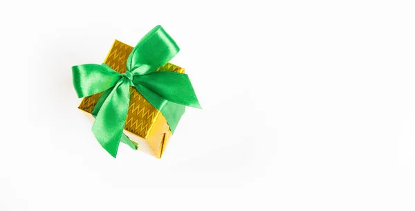 Błyszczący żółty pudełko z zieloną wstążką izolowane na białym tle. — Zdjęcie stockowe