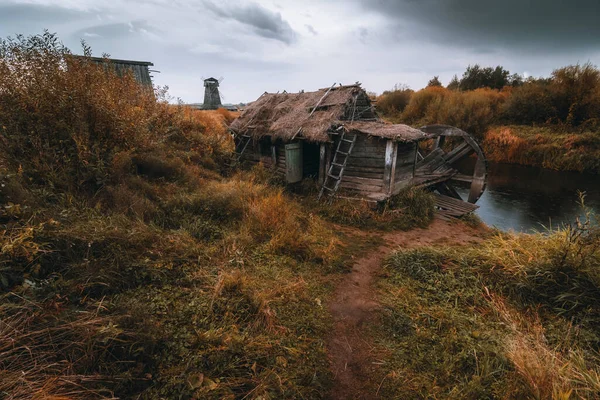 Dřevěný mlýn. Mračný podzimní den ve vesnici na venkově. — Stock fotografie