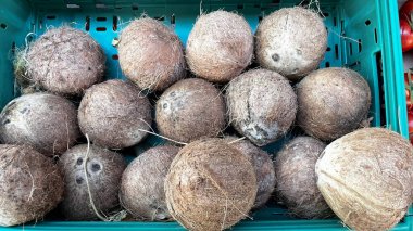 Plastik bir sandığa istiflenmiş hindistan cevizleri.