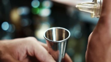 Kadehi ölçü cam, ağır çekim çelik dökme erkek barmen yakın çekim.