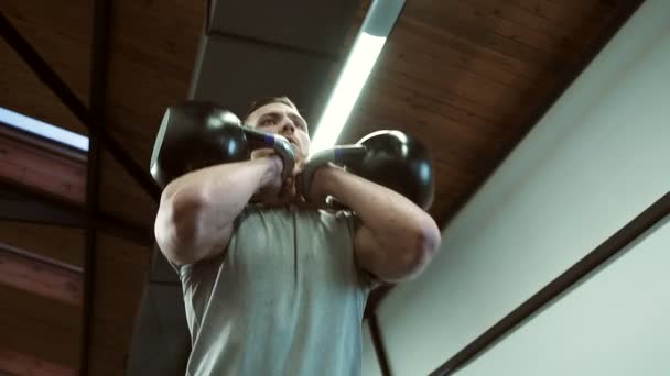 Retrato de atleta masculino guapo, que está teniendo un entrenamiento con teteras en el gimnasio moderno . — Vídeo de stock