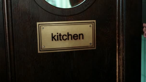Číšník se otevírá dveře kuchyně a jde ven s jídlo. — Stock video