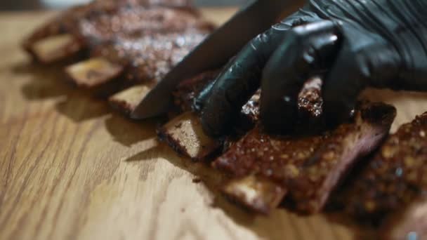 Zkušený šéfkuchař je řezání vepřová žebírka v kuchyni restaurace. — Stock video