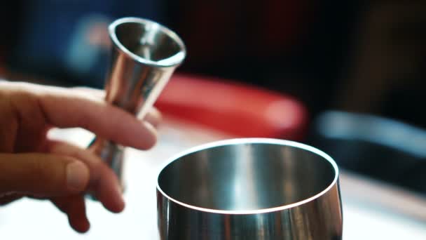 Joven barman está vertiendo agua en el vaso en la cocina del restaurante . — Vídeos de Stock