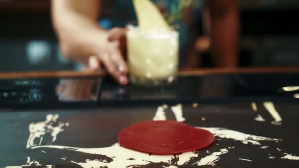 Jovem barman está colocando delicioso coquetel na mesa no lugar da moda . — Vídeo de Stock