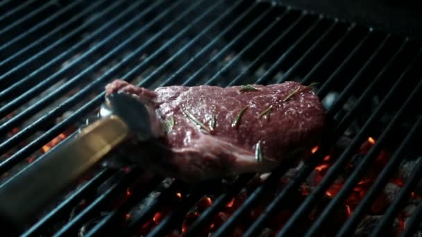 Professionell kock vänder köttbit på grillen i köket inomhus. Videoklipp
