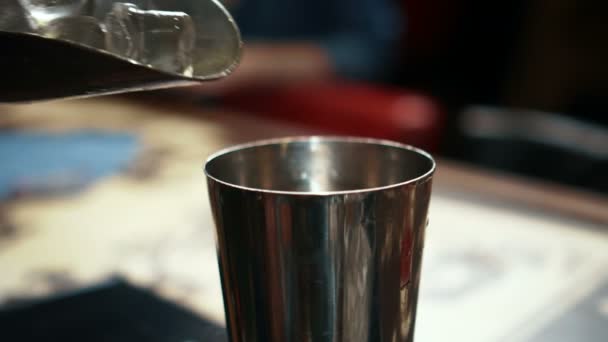 Manliga bartendern sätter is i glas i trendiga baren. Royaltyfri Stockvideo