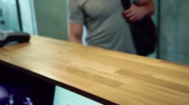 Adam fitness merkezi resepsiyonda anahtarları ve havlu alır.