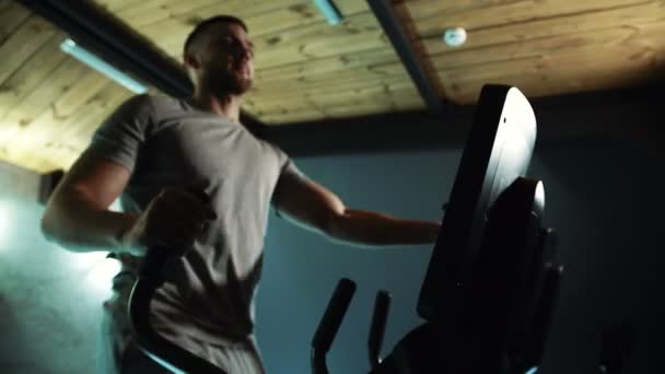 Portret van mannelijke atleet, die is bezig met zijn muscules op cross-trainer in de sportschool. — Stockvideo