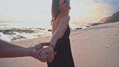 Mutlu beyaz çift birlikte yürüme süresi harcama tutuşup boş kumsalda gün batımında plaj. Deniz yaz tatil mutlu romantik seyahat kavramı