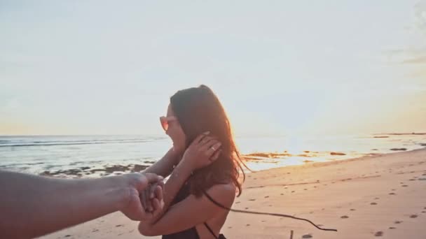 Ευτυχισμένος καυκάσιος Ζευγάρι ξοδεύουν το χρόνο μαζί με τα πόδια στην παραλία πιασμένοι χέρι χέρι στο ηλιοβασίλεμα στις άδειο παραλία. Βάγια ευτυχισμένη ρομαντικά ταξίδια διακοπές καλοκαίρι — Αρχείο Βίντεο