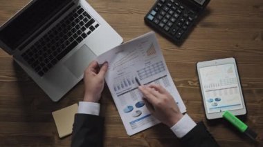 Üstten görünüm işadamı ofis masası bir sürü evrak ve finansal raporlar, dizüstü bilgisayarlar tarafından çevrili onun dizüstü ve tablet pc ile çalışma. İş, insanlar, evrak kavramı