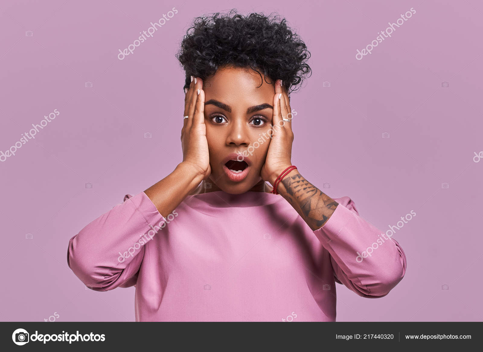 Young Lovely Dark Skinned Female Has Curly Hair Looks Surprisingly At Camera Keeps Jaw Dropped Wonders Sudden News Poses Against Lavender Background Facial Expressions Stock Photo By C Antianti