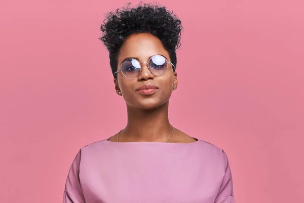 Empresária afro-americana feliz com sorriso positivo, tem cabelo escuro nítido, se alegra tendo fim de semana e bom descanso depois de trabalhar duro semana exaustiva, isolado na parede rosa — Fotografia de Stock