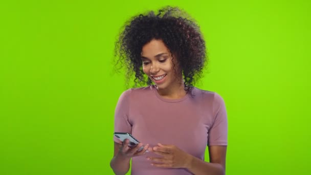 Neşeli Afrikalı Amerikan kadın telefonda iyi haber görmeye bakıyor — Stok video