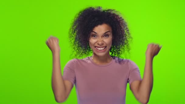 Портрет афро-американської молодої жінки з Кучеряве волосся радіє перемозі — стокове відео