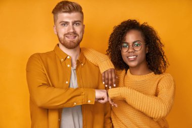 Young diverse couple gives fist bump, agree to bring the plan to life clipart