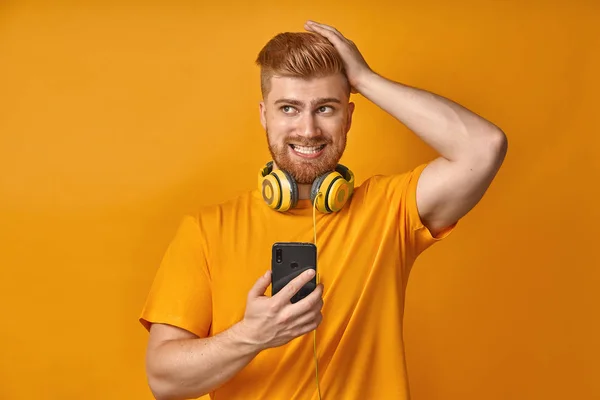 Kırmızı sakallı şaşkın adam cep telefonu tutan bir şey hakkında unutur