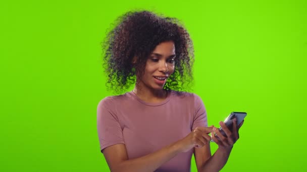 Şaşırtıcı koyu tenli kadın akıllı telefon cihazını işaret ediyor. — Stok video