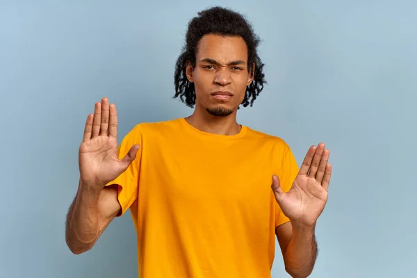 Ung blandras man i gul skjorta visar stopp med handflatorna — Stockfoto