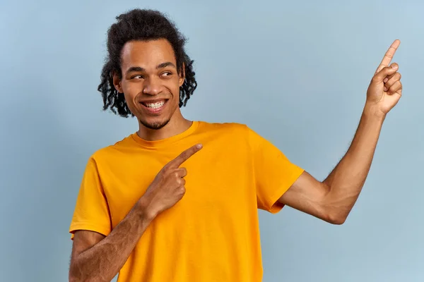Aktiv leende afrikansk amerikansk ung kille i gul skjorta pekar finger — Stockfoto