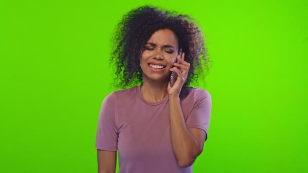Mladá emocionální Afroameričanka mluví po telefonu a tance na chromakey — Stock video