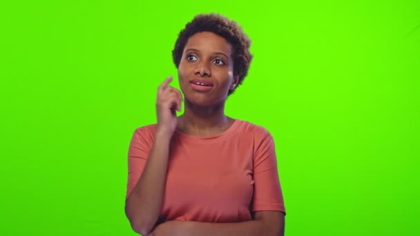 Afro-Amerikaanse vrouw droomt in perzik t-shirt op groen scherm chroma sleutel — Stockvideo