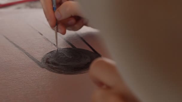Şövalenin önünde sandalyede oturan kadın ressam, tuvale yağlı boya sürüyor. — Stok video
