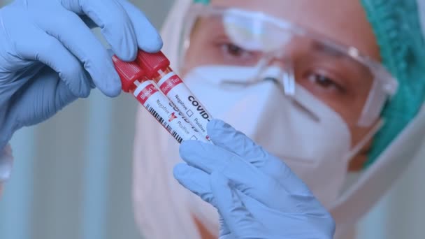 Besorgte Ärztin analysiert Reagenzglas mit Coronavirus — Stockvideo