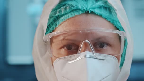 Stanco giovane medico donna in cappello e maschera protettiva viso togliersi gli occhiali — Video Stock