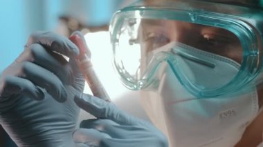Erkek doktor, COVID-19 virüsünün kan örneğini kontrol etmek için kan testi tüpü tutuyor.