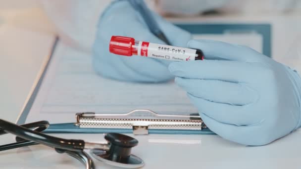 Close up af læger håndholdt rør med positiv blodprøve for SARS-CoV-3 – Stock-video