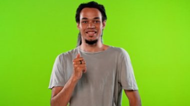 Sıradan kıyafetli çekici Afro-Amerikan adam kroma tuşunun üzerinde dans ediyor.