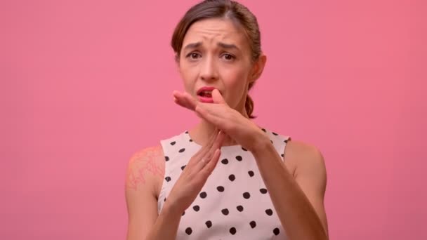 Емоційна молода жінка просить тайм-аут на рожевому фоні стіни . — стокове відео