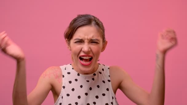Enojada loca histérica mujer gritando en voz alta con rabia sobre fondo rosa. — Vídeos de Stock