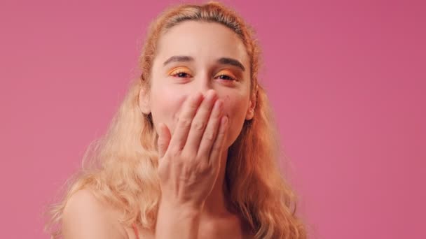 Portrait of a woman who sends an air kiss on a background of a pink wall. — Stock Video