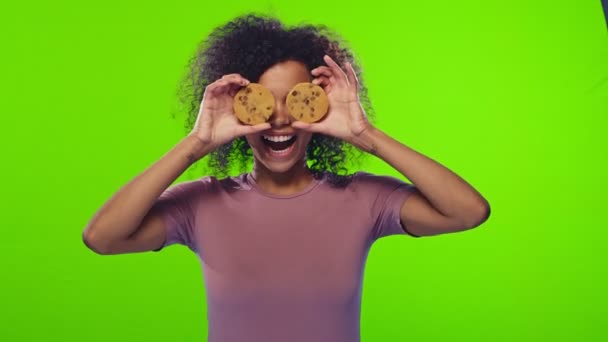 Африканська самиця бере два круглих здорових печива і робить з них окуляри. — стокове відео