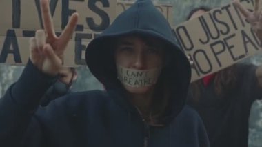 Kişi, ırkçılık karşıtı yürüyüşe katılan barış hareketini gösteriyor
