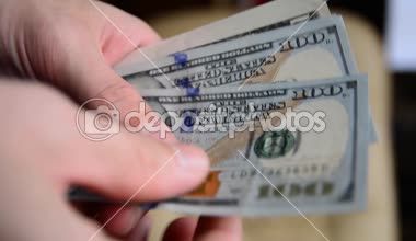 Bir adam Amerikan Doları elleriyle sayar.