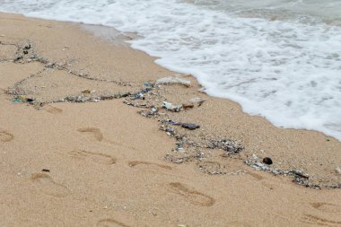 Tayland 'daki kirli, sessiz sahilde küçük bir dalga.